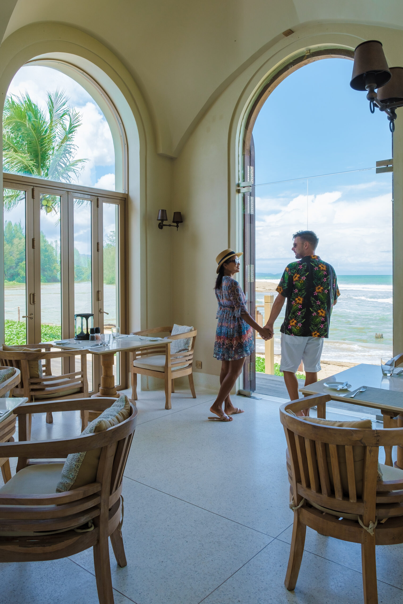 couple of men and women walking at an old gate during vacation at a luxury resort in Thailand.